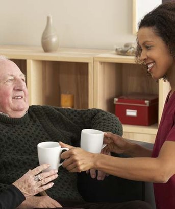 Carer sharing a cup of tea with a client